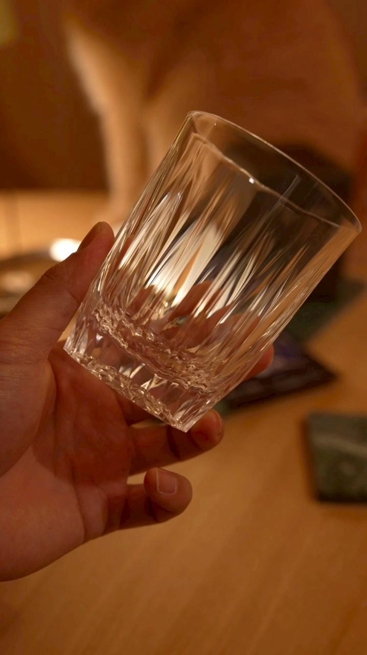手持 KINJO JAPAN E1 Clear 透明矽膠杯，暖光下呈現清透質感